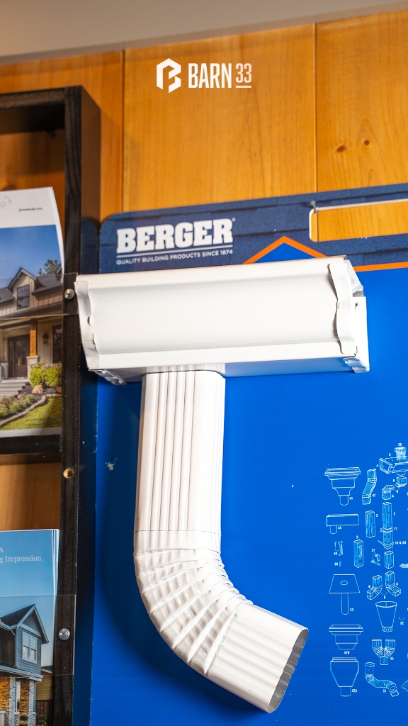 Berger seamless aluminum K-style gutter end cap outlet drop and corrugated downspout elbow display at Barn 33